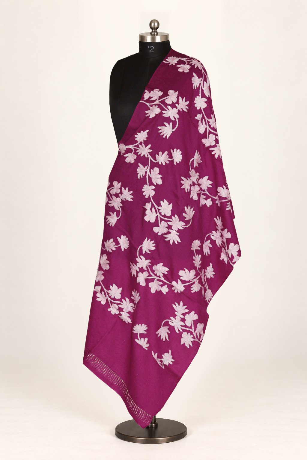 Purple merino wool stole draped over a mannequin’s shoulder, with large ivory Aari flowers and curling leafy vines