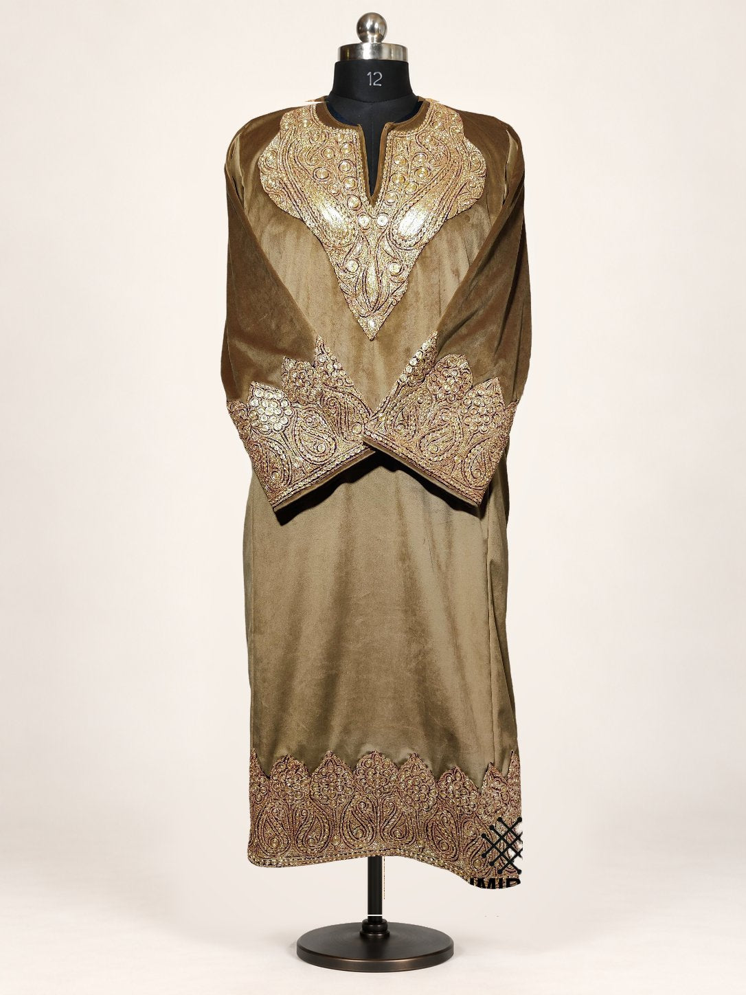 Brown velvet pheran on a mannequin, with golden Tilla paisley embroidery around the neckline, crossed cuffs and hem