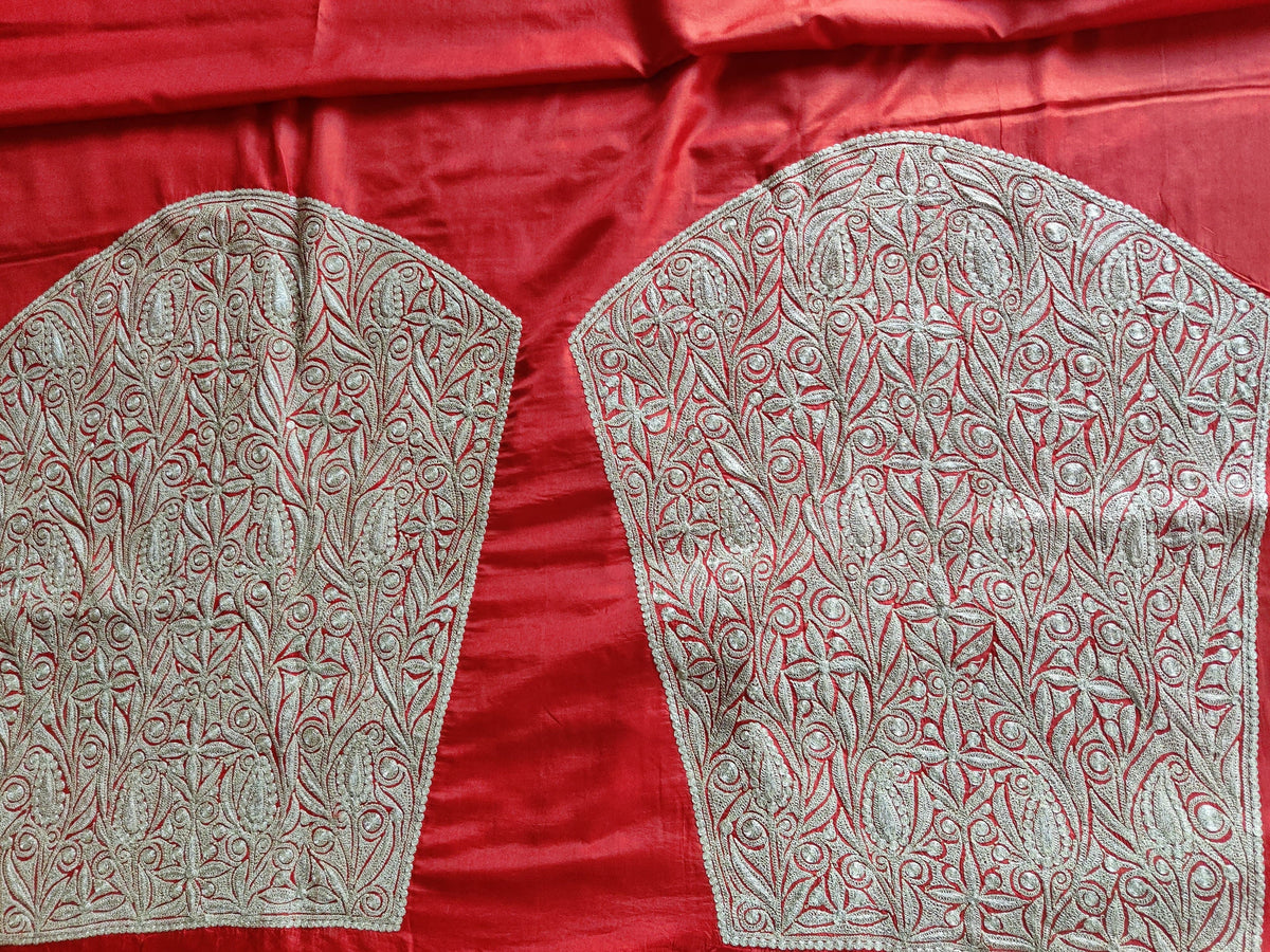 Two matching sleeve panels densely embroidered with silver-toned Tilla flowers and scrolling leaves on red silk
