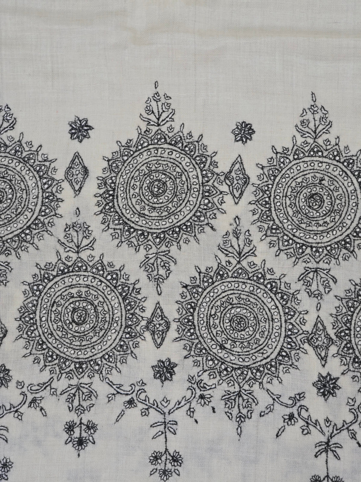 Detail of the ivory shawl's black circular medallions linked with delicate floral sprigs