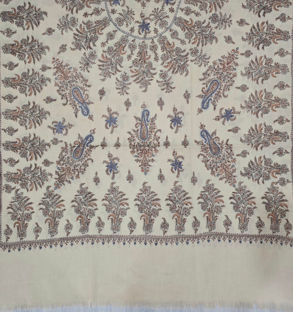 Lower section of a cream Pashmina shawl with large paisleys, rows of leafy sprays, a narrow border and a plain fringed end