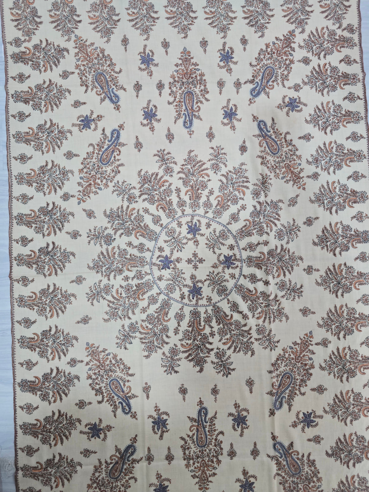 Cream Pashmina shawl spread flat, showing a circular arrangement of leafy sprays, large blue-edged paisleys and scattered small motifs