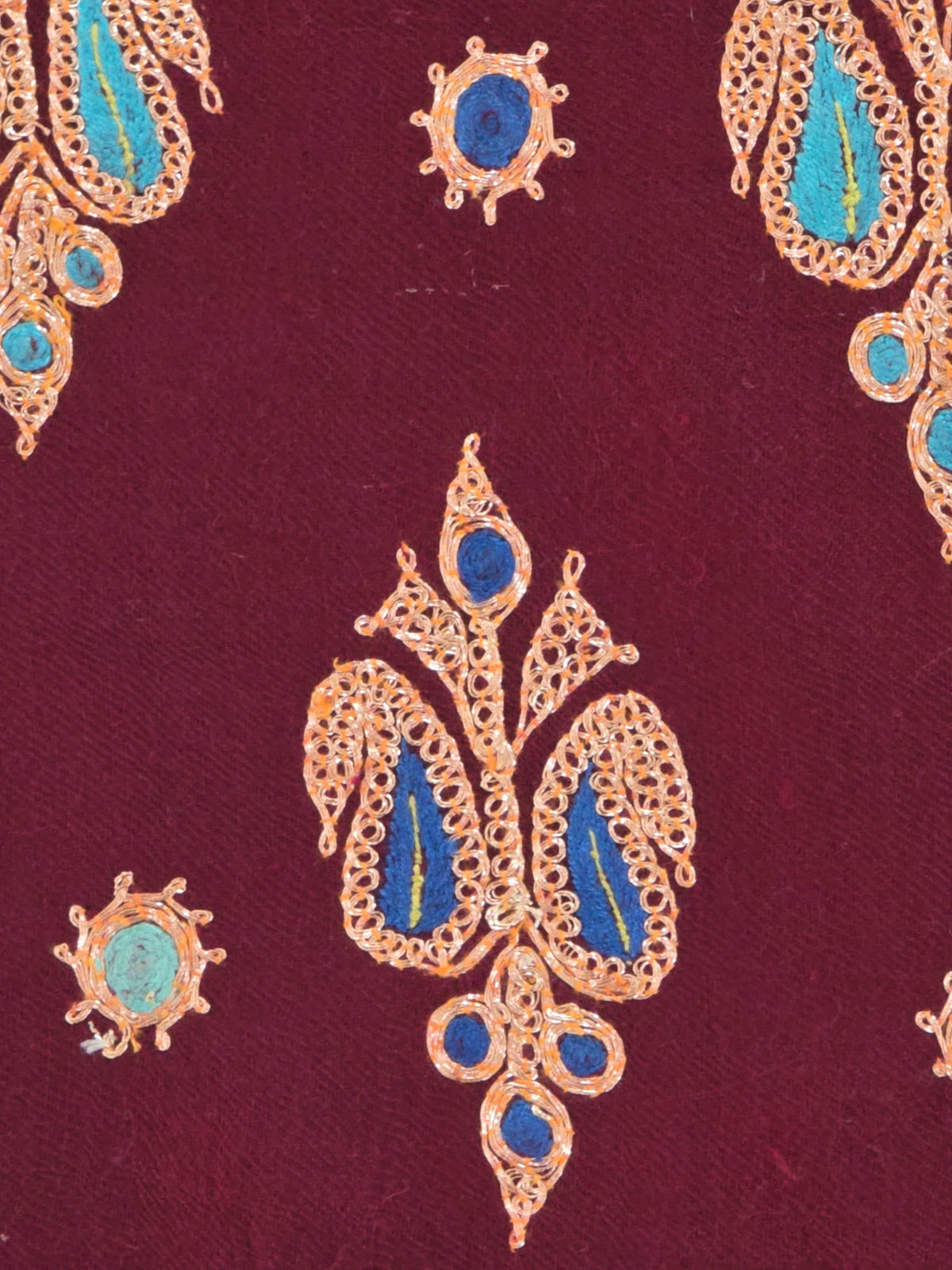 Close-up of a gold embroidered motif with deep blue centres and small turquoise accents on garnet Pashmina shawl