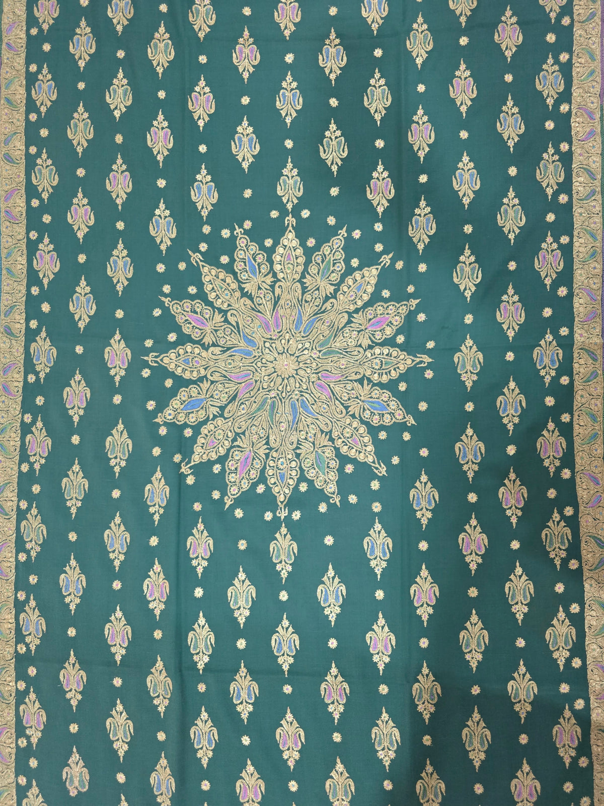 Emerald-green Pashmina shawl laid flat, showing a large central gold medallion, rows of small motifs and ornate side borders