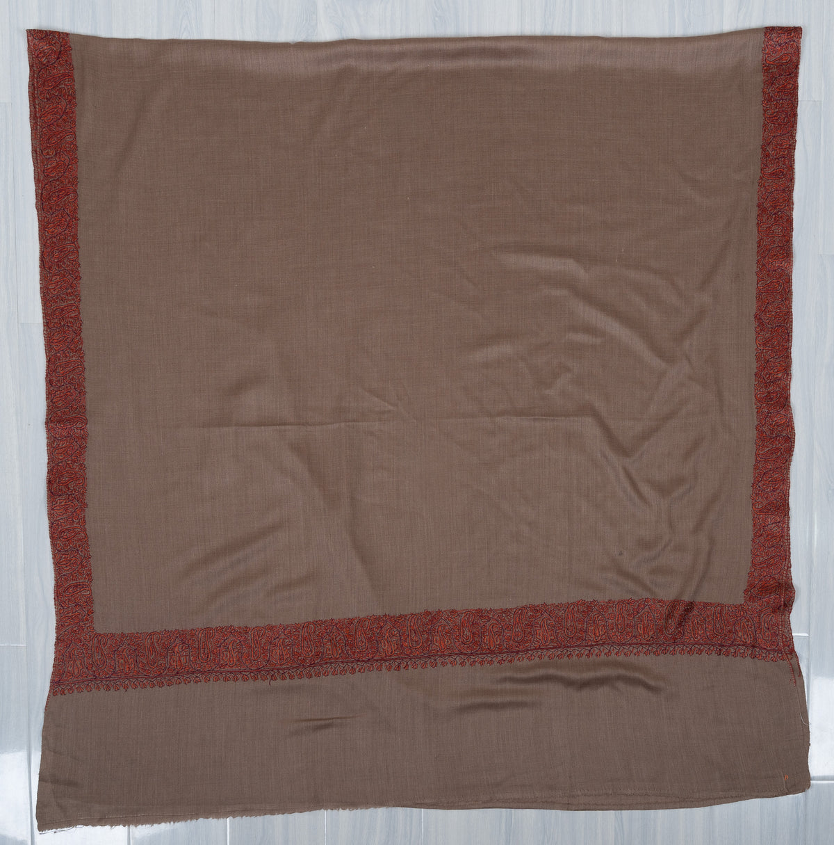 Mocha-brown Merino wool shawl laid flat, with rust borders framing a plain field