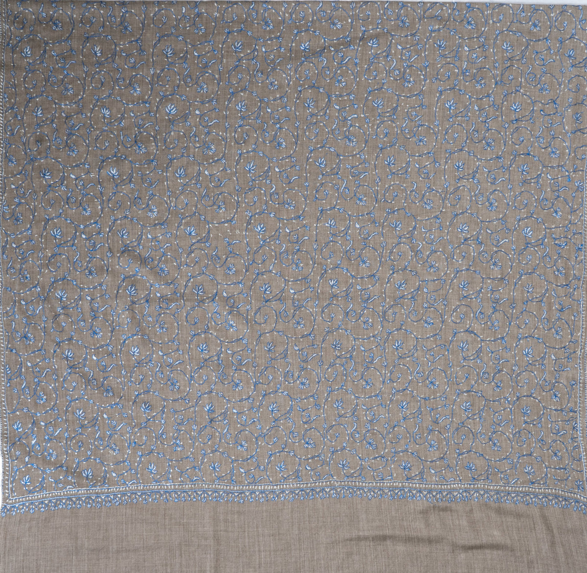 Grey shawl spread flat with an all-over network of fine blue floral vines enclosed by a narrow embroidered border