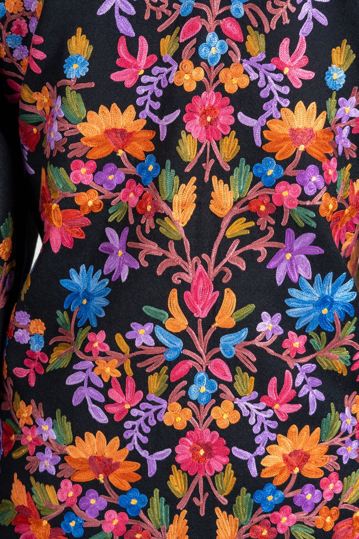 Close-up of symmetrical multicoloured Aari floral vines covering the black jacket’s back.
