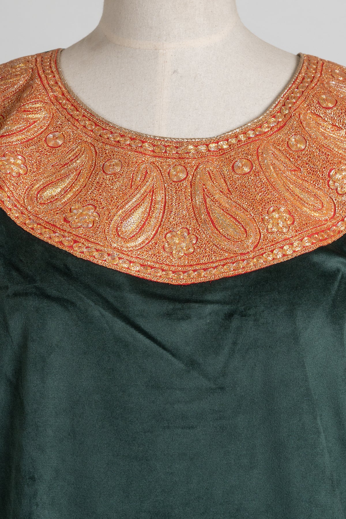 Close-up of the broad copper-gold Tilla neckline on a green velvet suit top, with repeated paisleys and small flowers
