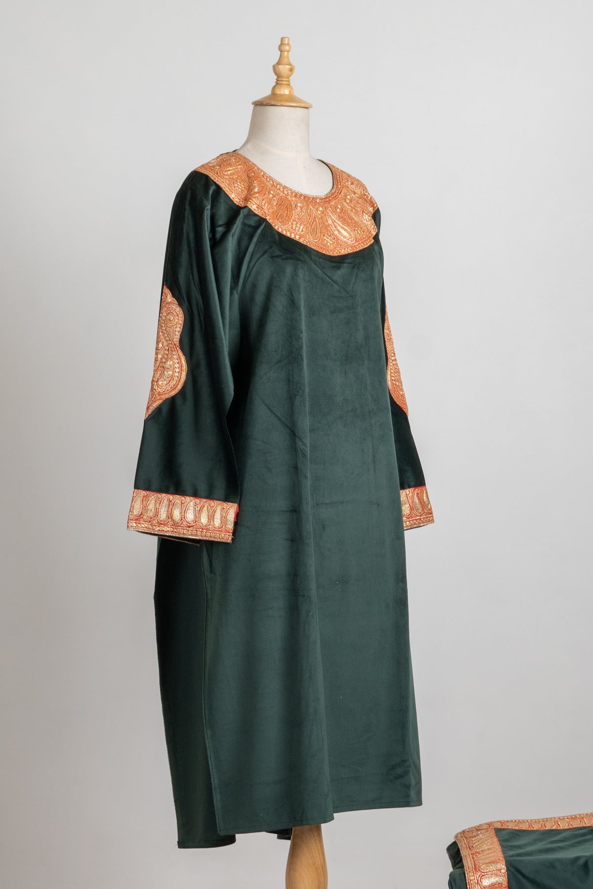 Angled full view of a forest green velvet suit top with Tilla neckline and sleeve embroidery, a matching folded stole beside it