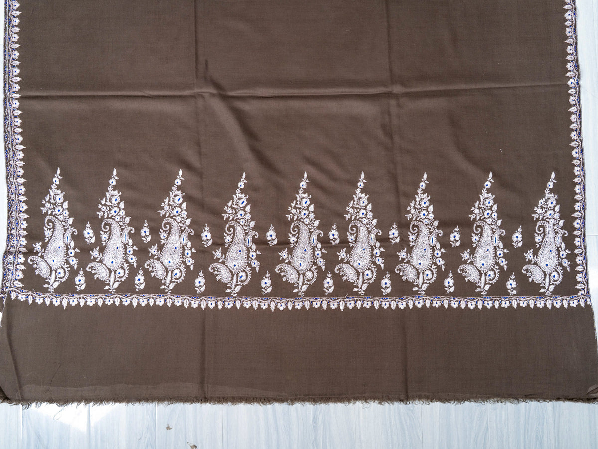 Mocha-brown shawl's embroidered end, showing tall ivory paisley sprays above a plain strip and fine fringe