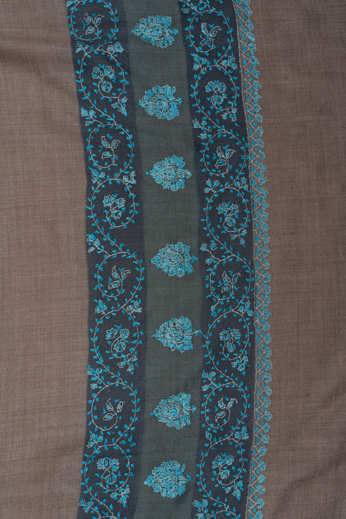 Close-up of teal Sozni floral vines and small motifs in parallel bands along a dark shawl border