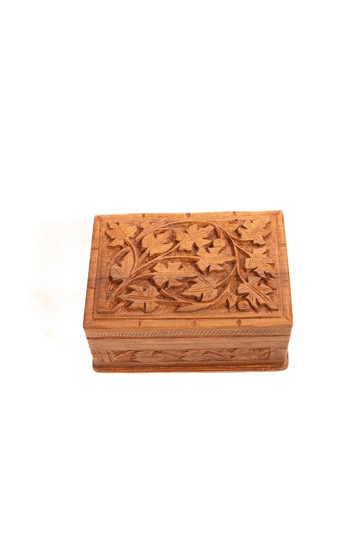 Closed walnut wood box viewed from above, showing a carved leaf lid and decorated front panel