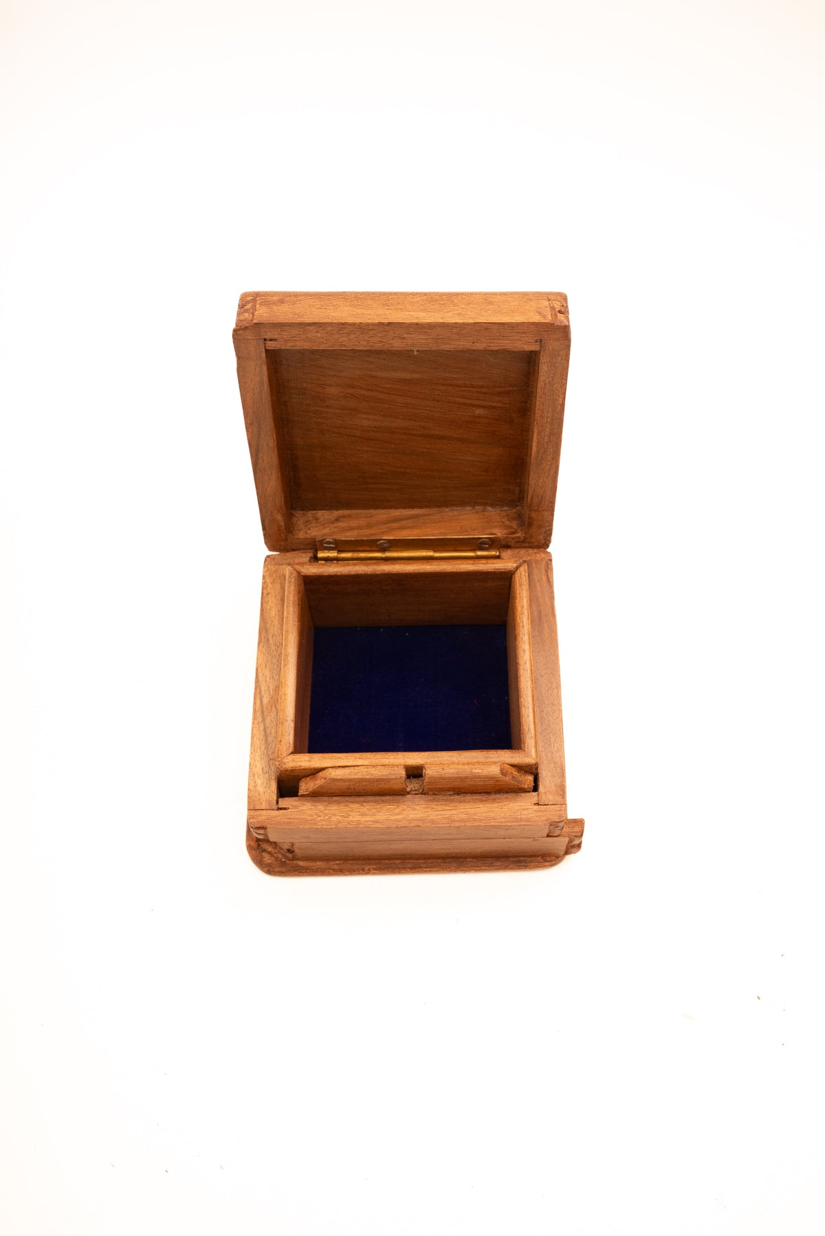 Top-front view of the open walnut box showing a dark blue-lined compartment and brass-coloured hinge