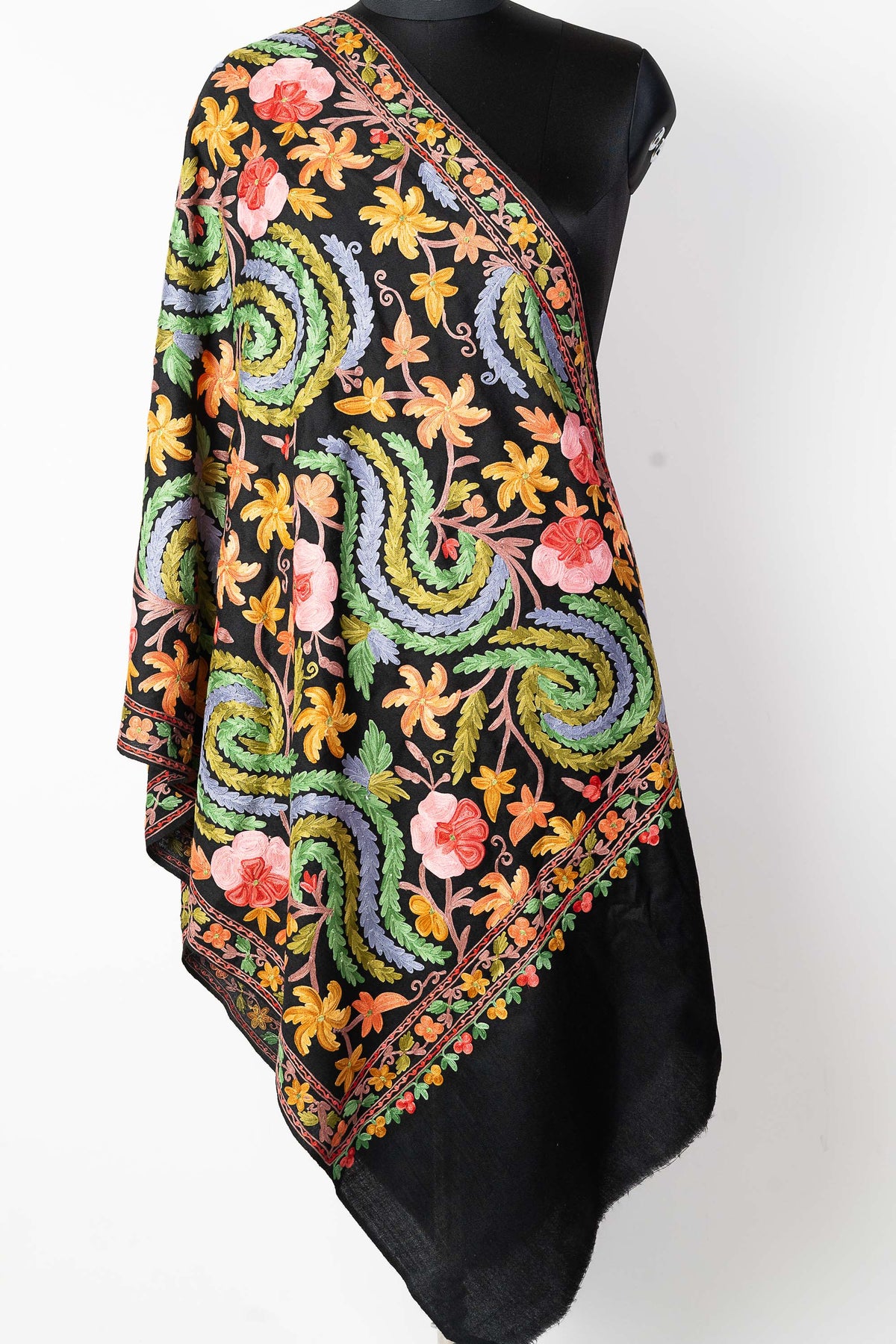 Full draped view of a black stole with colourful floral embroidery, large green-and-lavender curves and a plain black end.