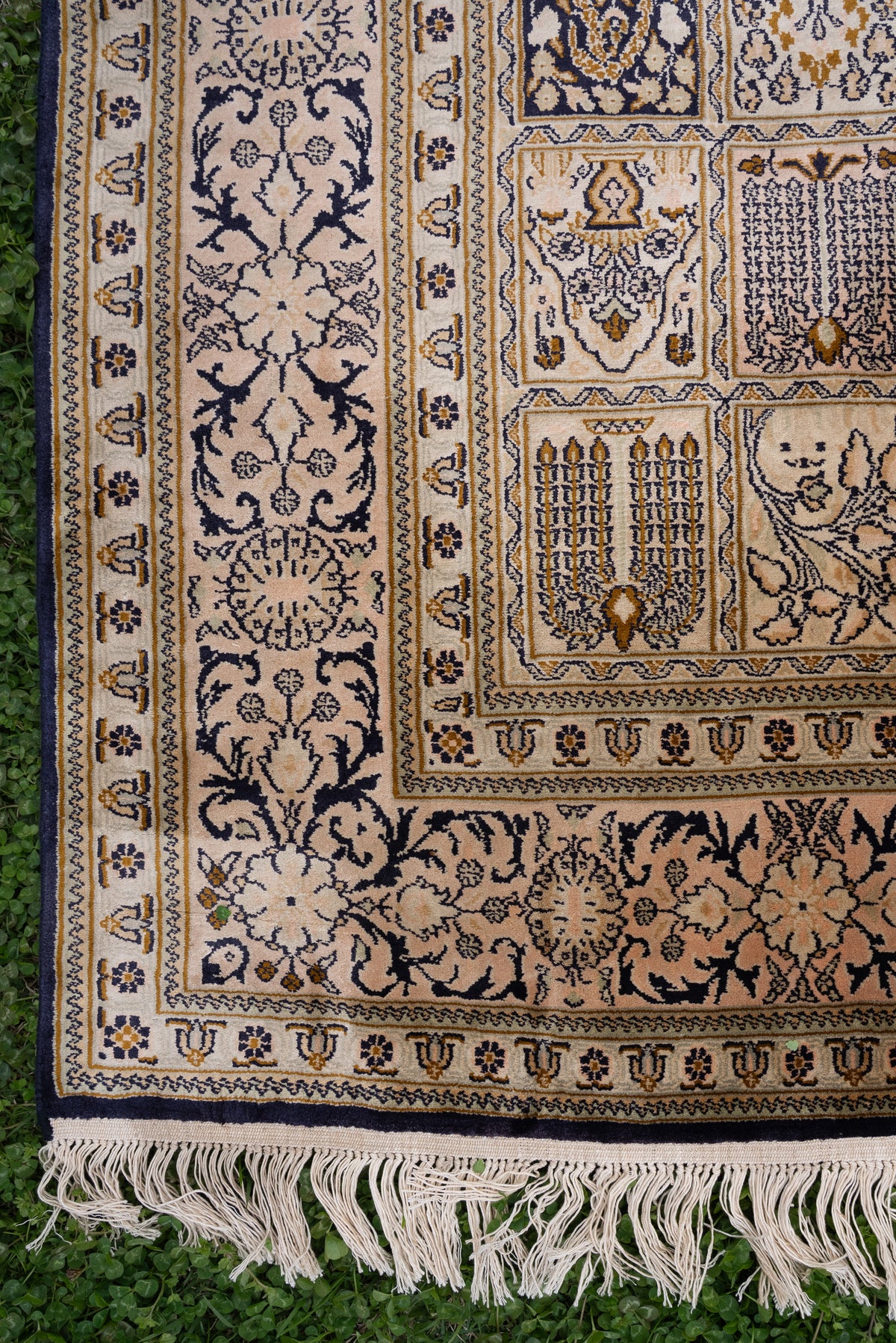 Lower side of the ivory silk carpet, showing small patterned panels, floral borders and pale fringe