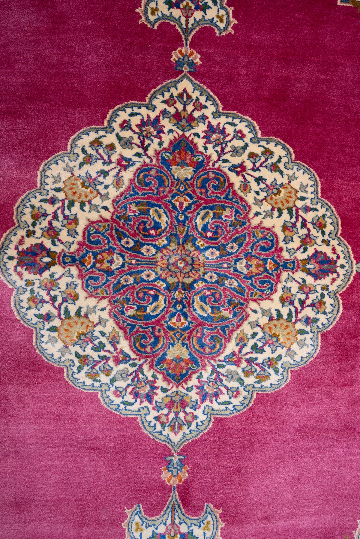 Close-up of the ornate cream and blue floral medallion on the rose-pink carpet