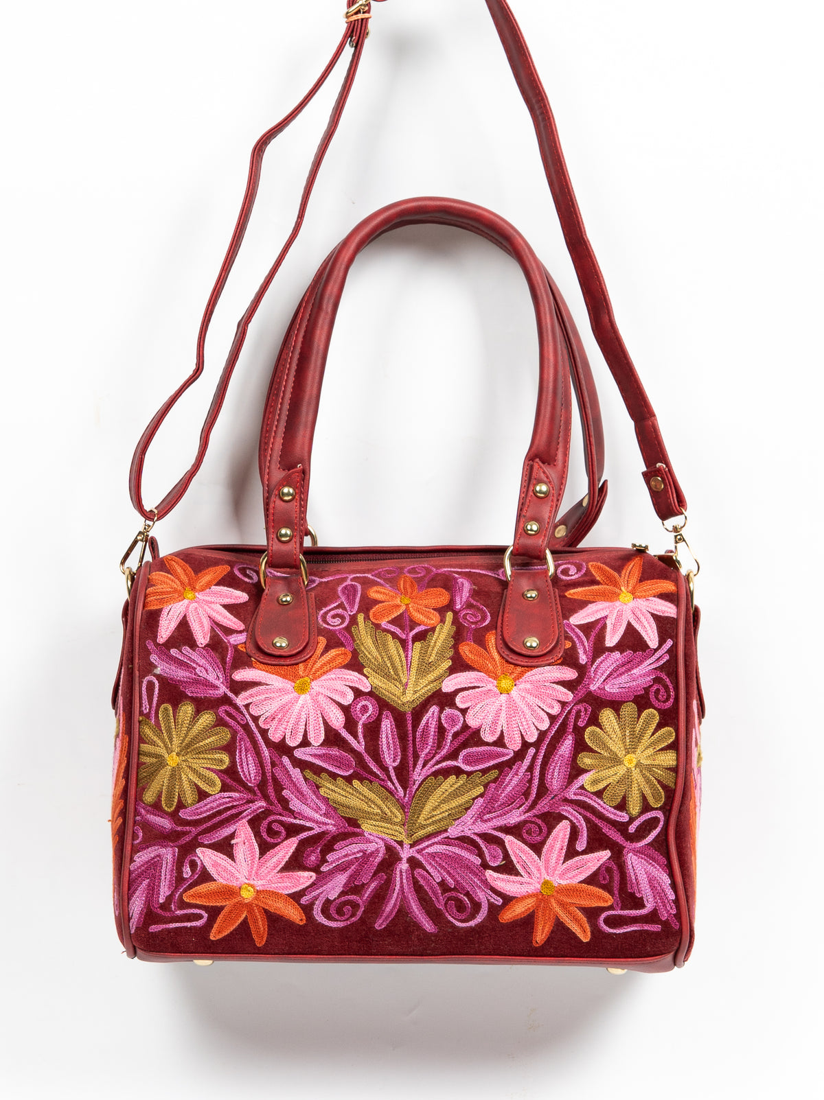 Maroon handbag hanging from its long shoulder strap, with double handles and a symmetrical pink, orange and green floral panel