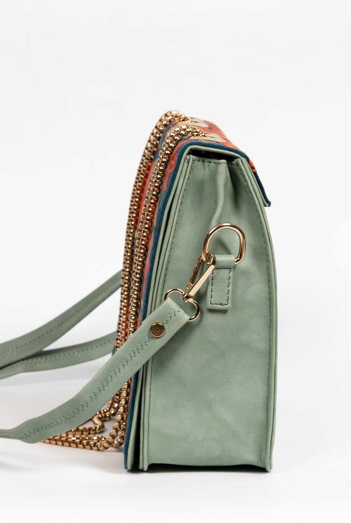 Side view of the pale green bag panel with a gold-toned ring, clipped shoulder strap and chain draped behind