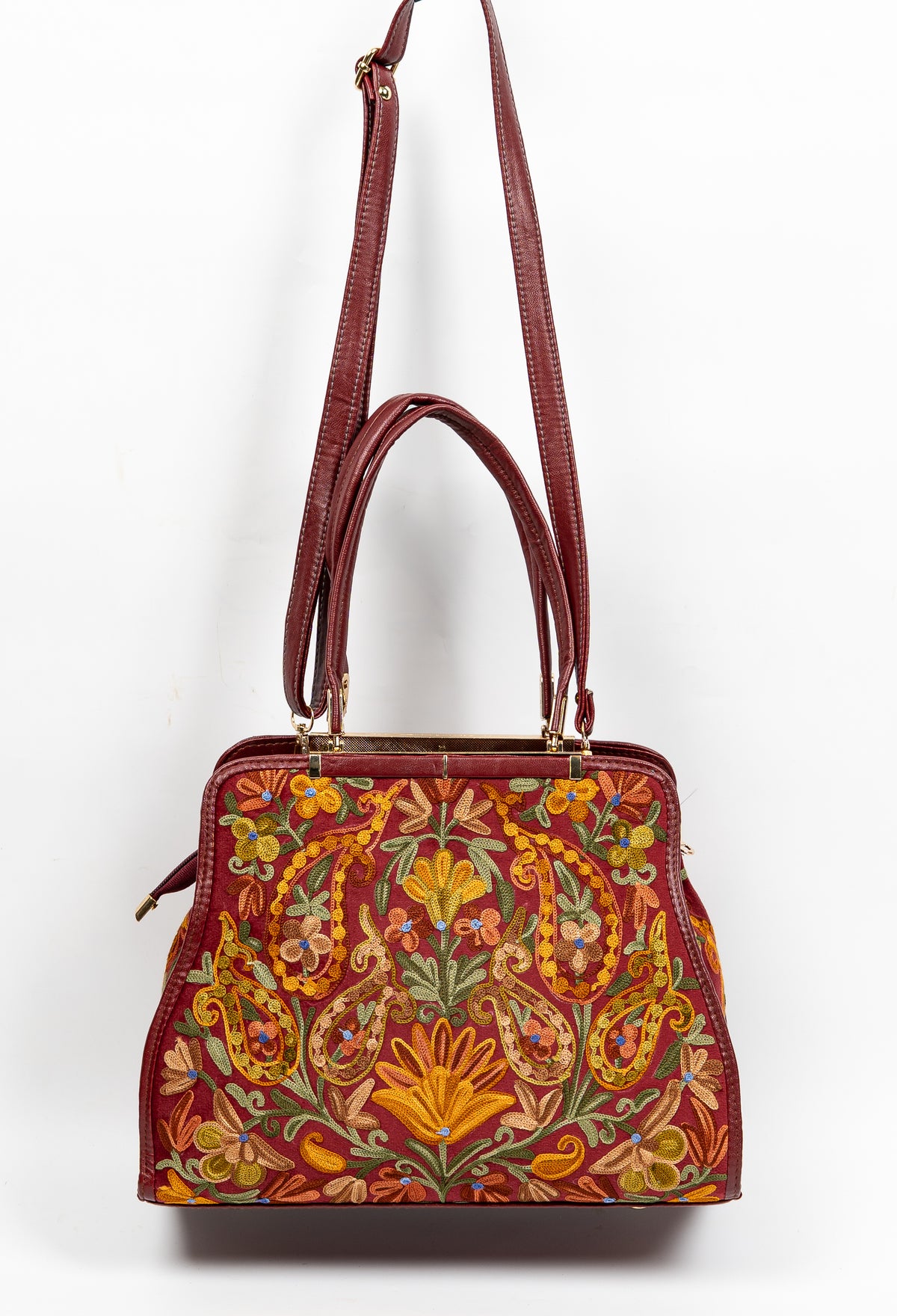 Maroon Aari floral handbag hanging from a long burgundy shoulder strap, with double handles and gold-toned fittings