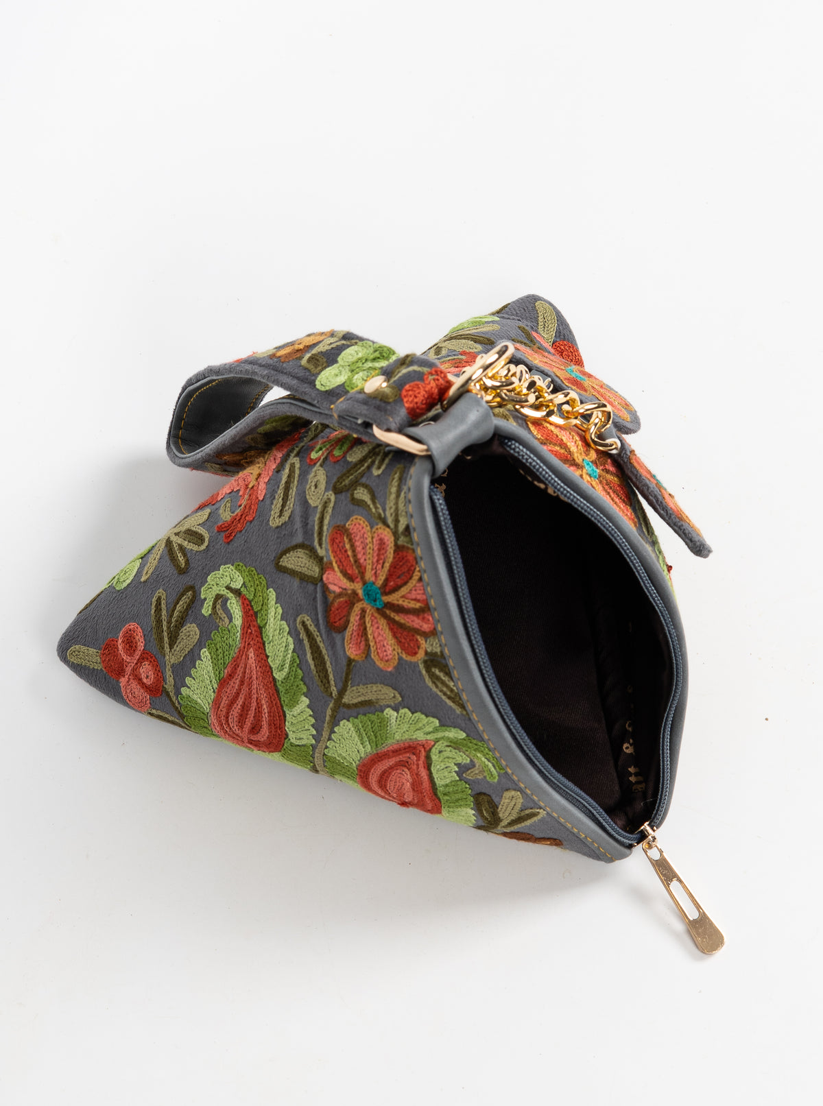 Charcoal pyramid bag lying open at an angle, with a dark interior, short handle and colourful paisley embroidery