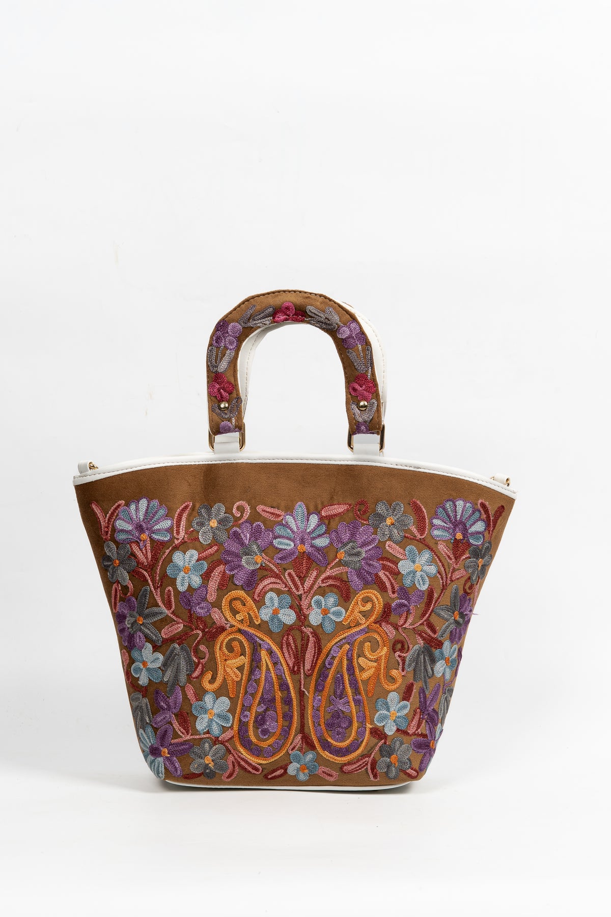 Straight-on view of the brown tote with curved embroidered handles, blue-purple flowers, golden paisleys and a white top edge.