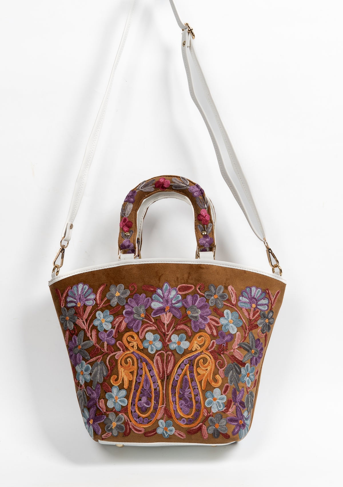 Brown floral tote hanging from its long white strap, with embroidered short handles and paired golden paisleys on the front.