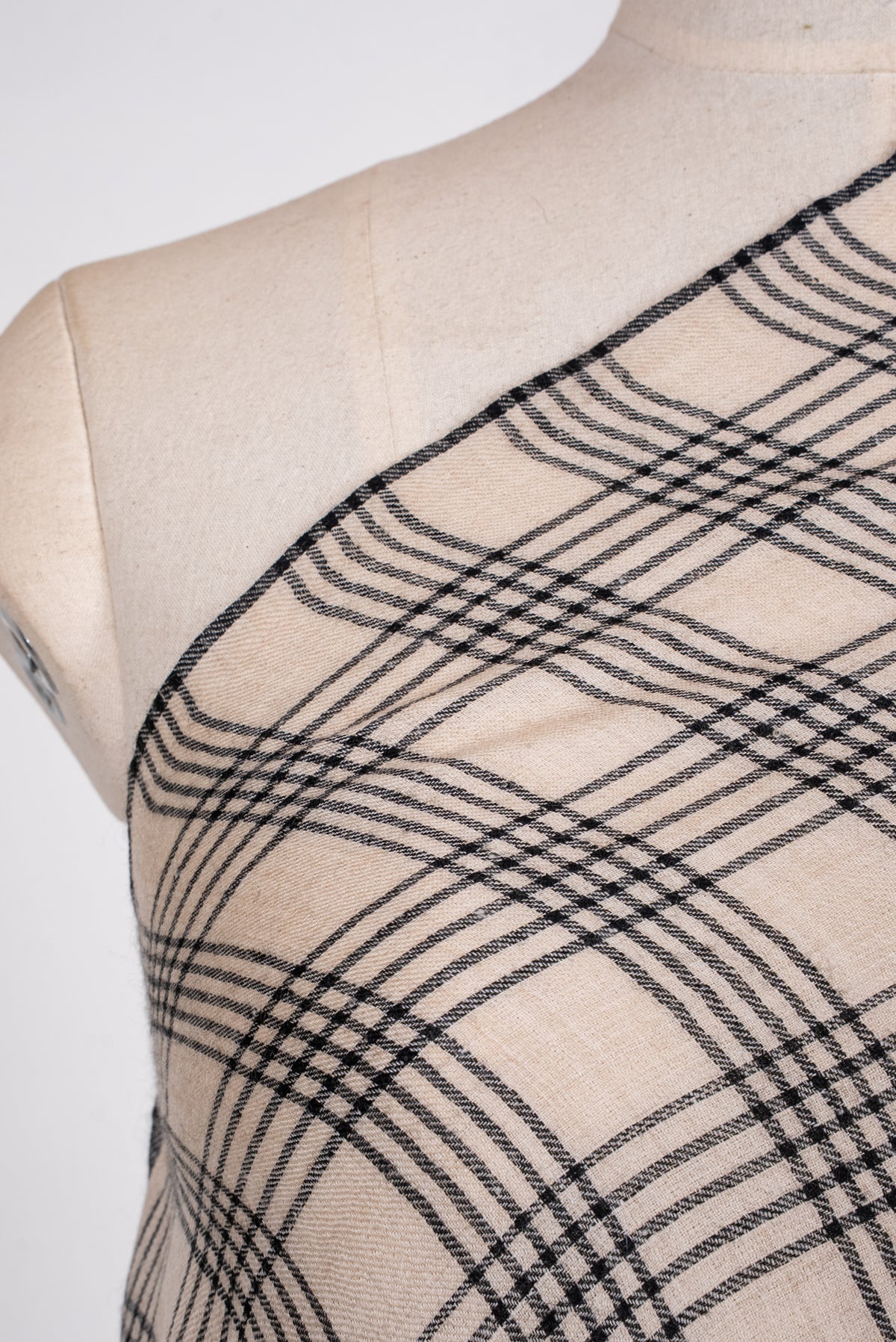 Shoulder close-up of ivory Pashmina scarf with intersecting groups of fine black plaid lines
