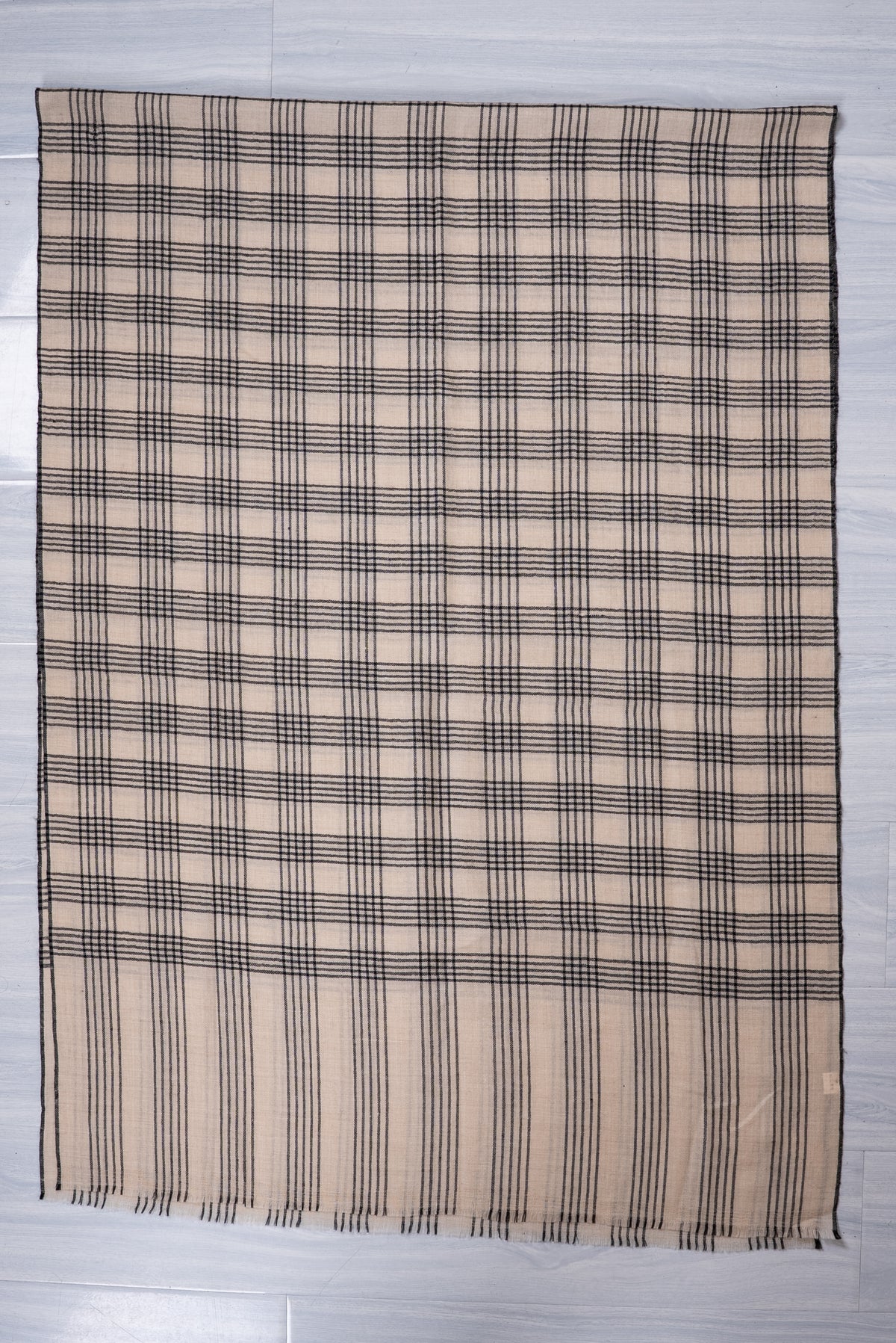 Ivory Pashmina scarf spread flat, with black plaid checks, a striped end panel and short fringe