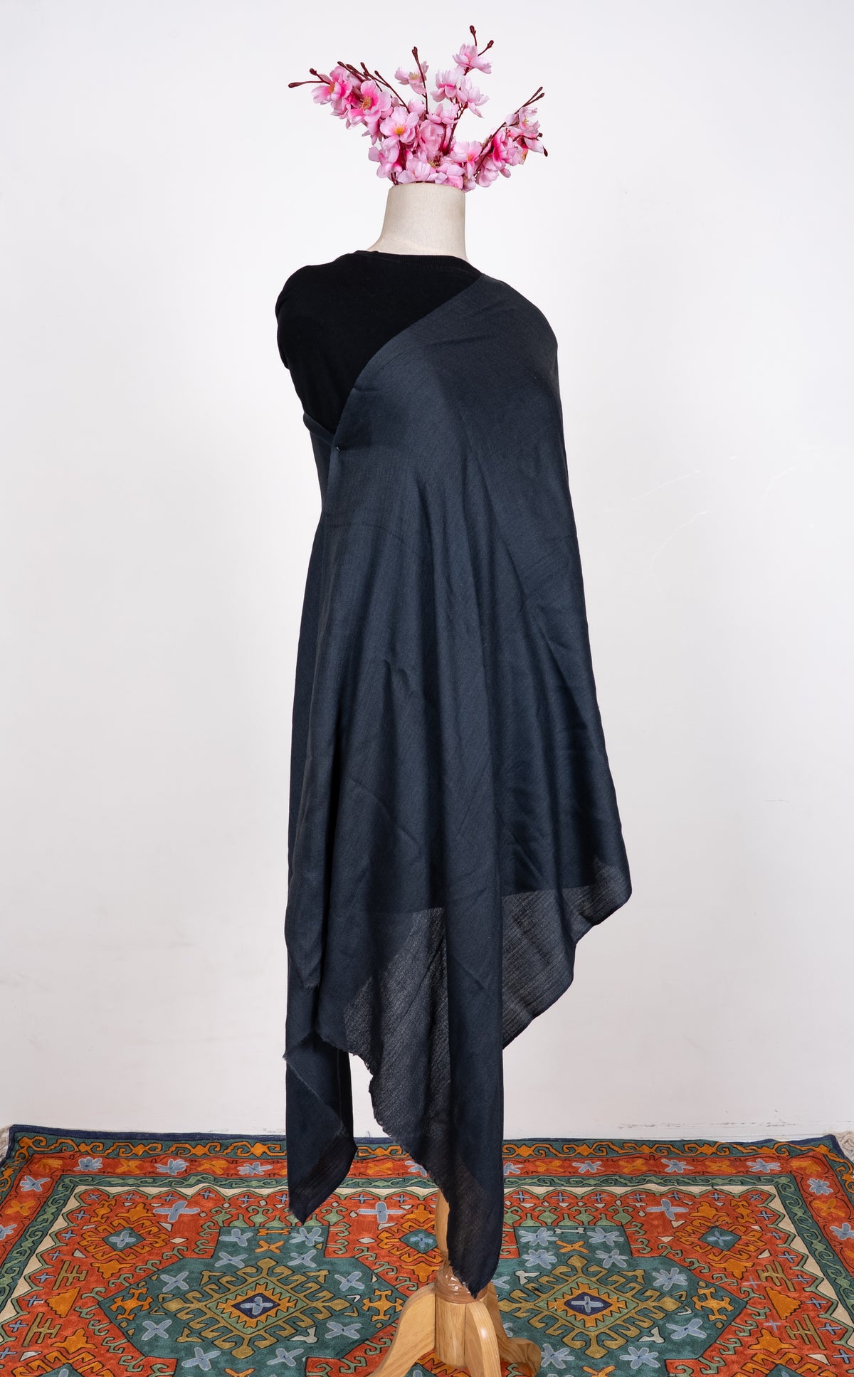 Plain midnight-blue scarf wrapped around a mannequin, with long softly folded ends hanging down the front.