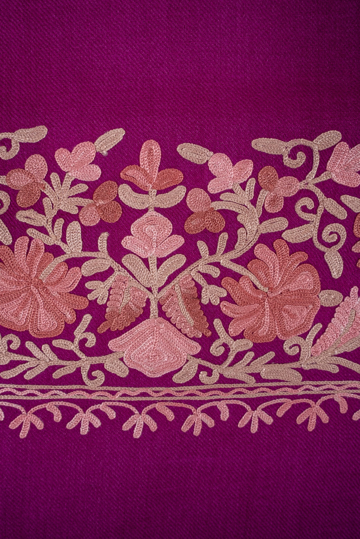 Close-up of the magenta scarf’s blush-and-beige embroidered flowers, curling stems and small leafy border