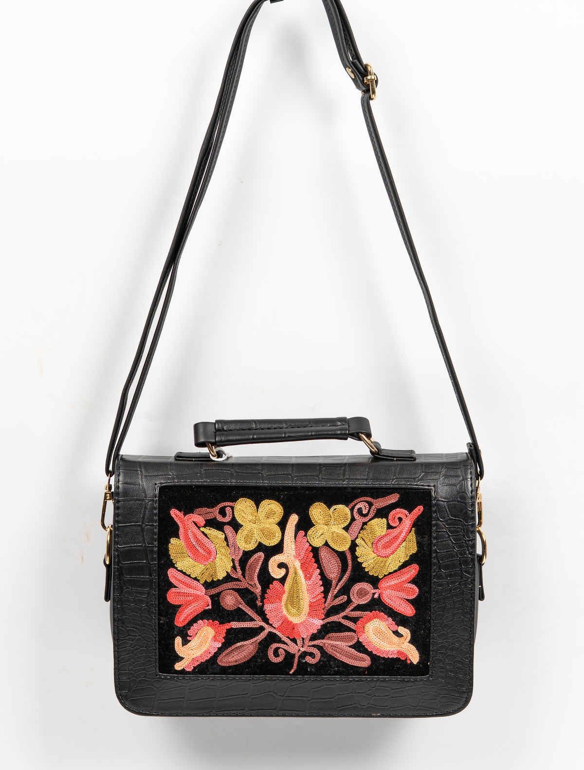 Black handbag hanging from a long shoulder strap, with a top handle and a coral-and-gold embroidered front panel