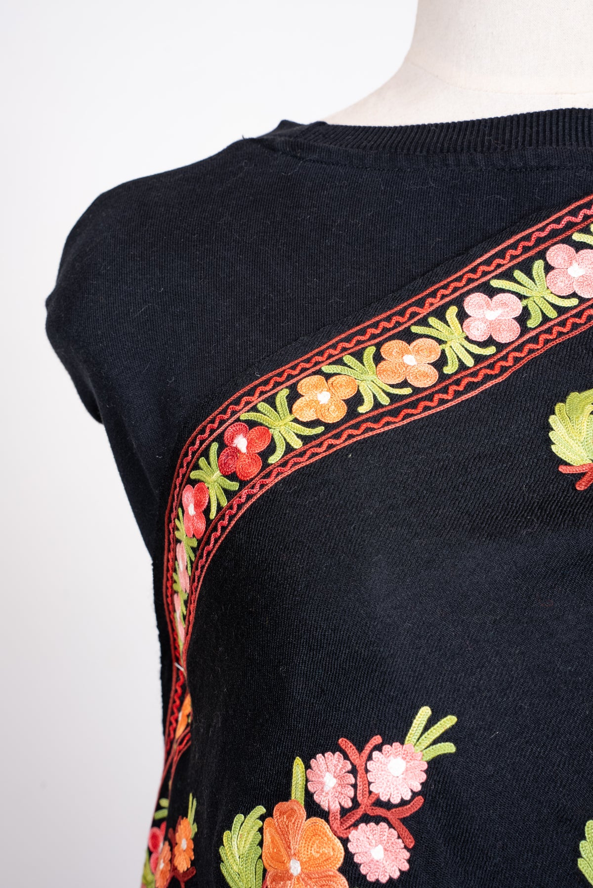 Shoulder detail of black shawl with a narrow multicoloured floral Aari border and scattered bouquet motifs