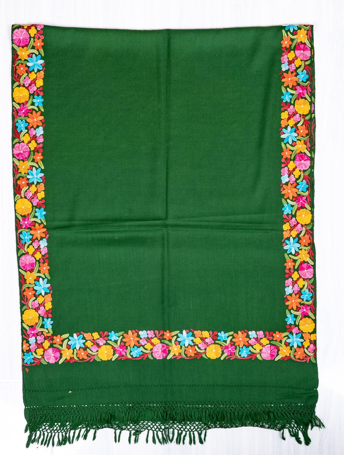Forest-green shawl spread flat, showing a plain field framed by bright multicoloured Aari flowers and a fringed end