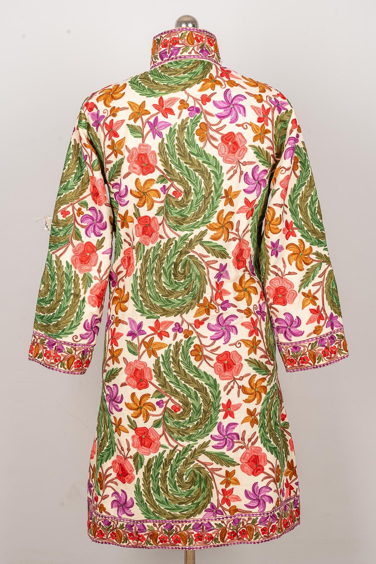 Back view of the white jacket, showing large green leafy swirls among pink, purple and orange flowers