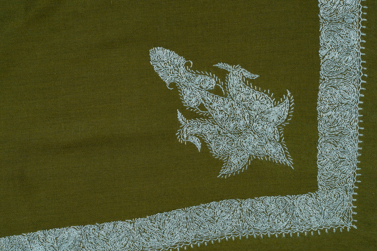 Olive-green rumal corner laid flat with a pale blue Sozni paisley inside a fine leafy border