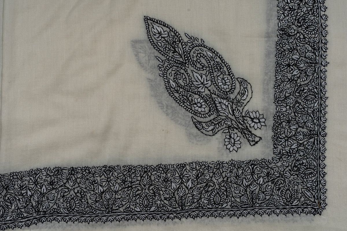 Ivory rumal corner with an ornate black Sozni floral motif inside a dense embroidered border