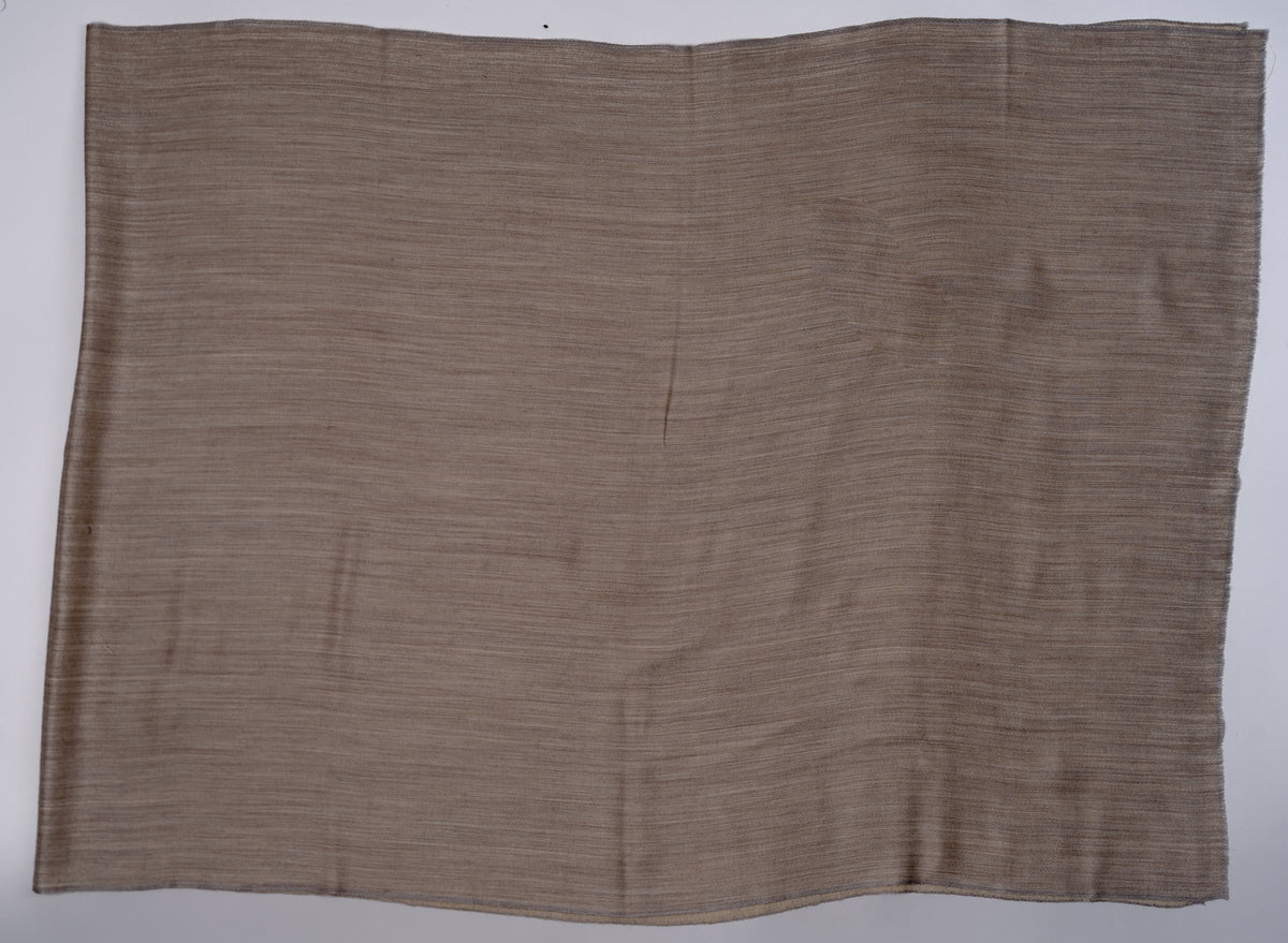 Darker sand-brown side of a plain reversible Merino wool stole spread flat, showing the rectangular shape and fine woven texture