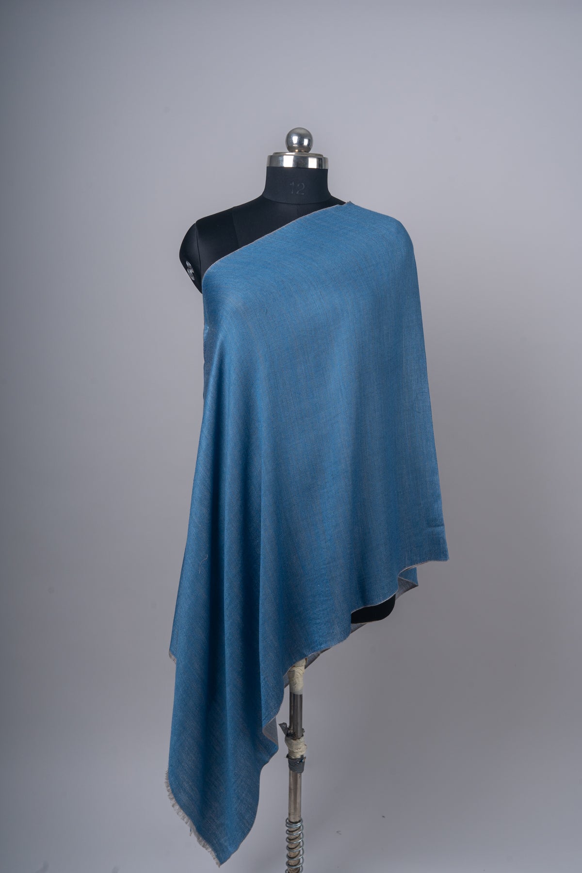 Front view of the azure-blue stole draped over one shoulder in soft folds, with a narrow grey reverse edge.