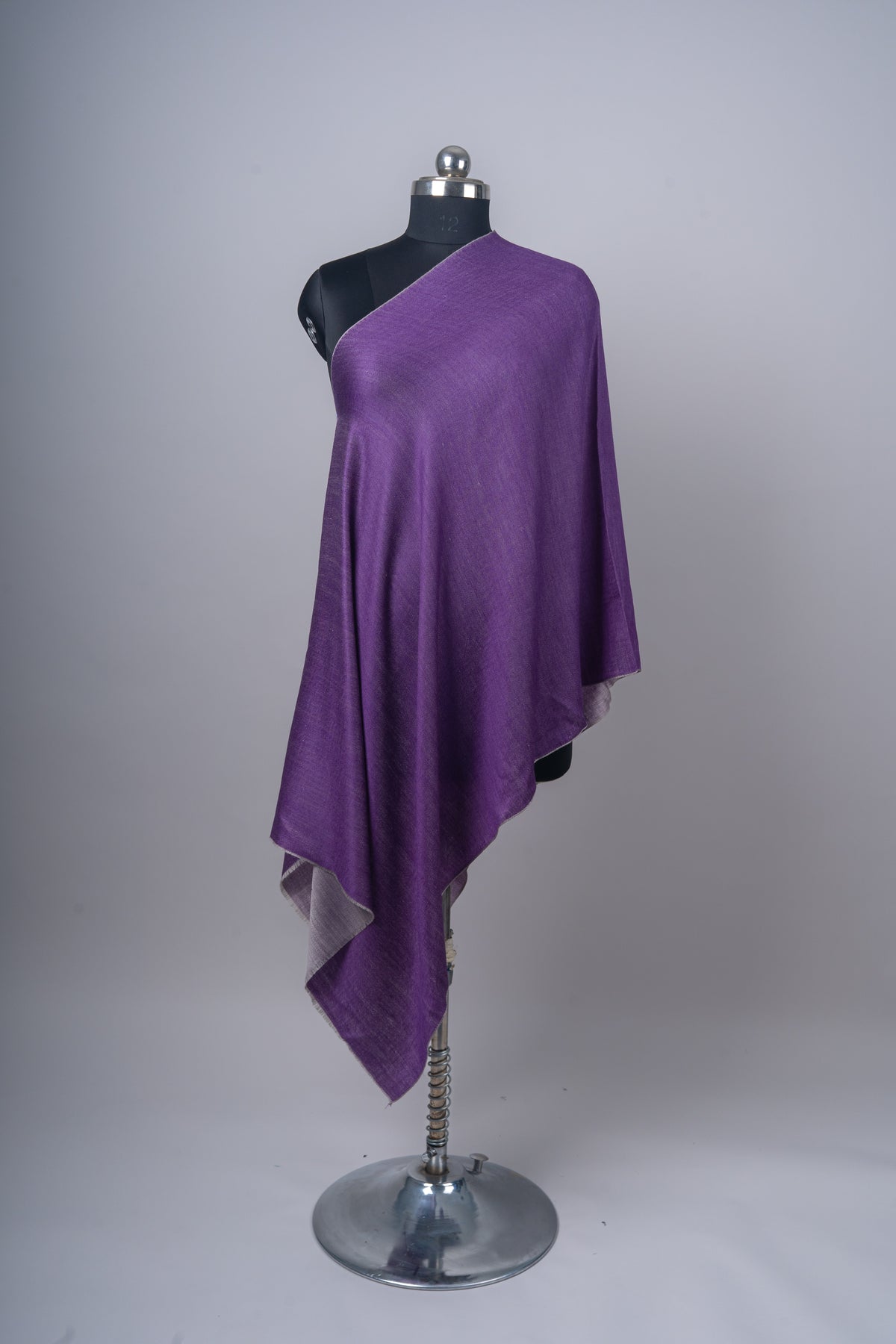 Full view of a purple reversible stole draped diagonally on a mannequin, with ash grey reverse visible at the hanging corner