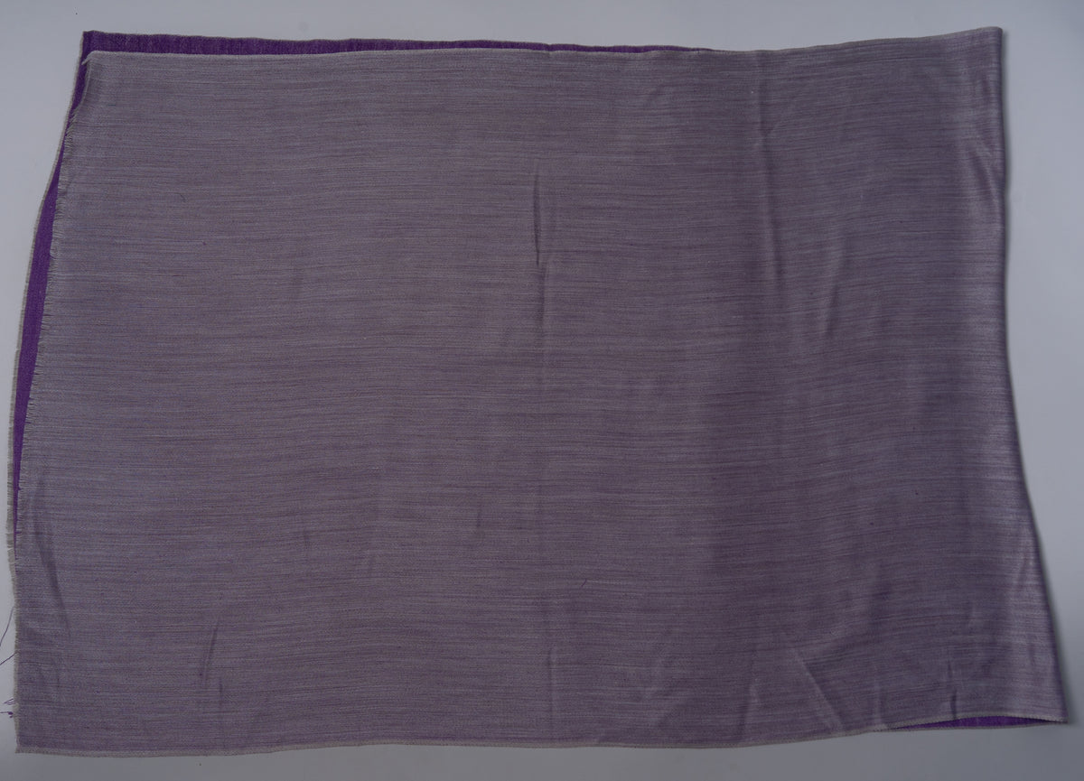 Ash grey reverse of a rectangular Merino wool stole laid flat, with the purple side visible along the upper and left edges