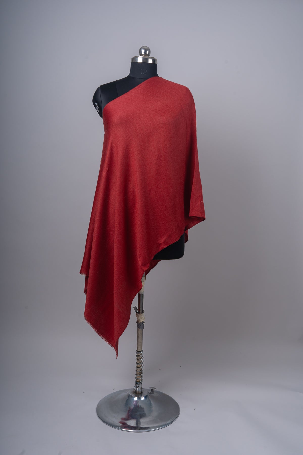 Full-length front view of a crimson Merino wool stole on a black mannequin, with a long hanging corner