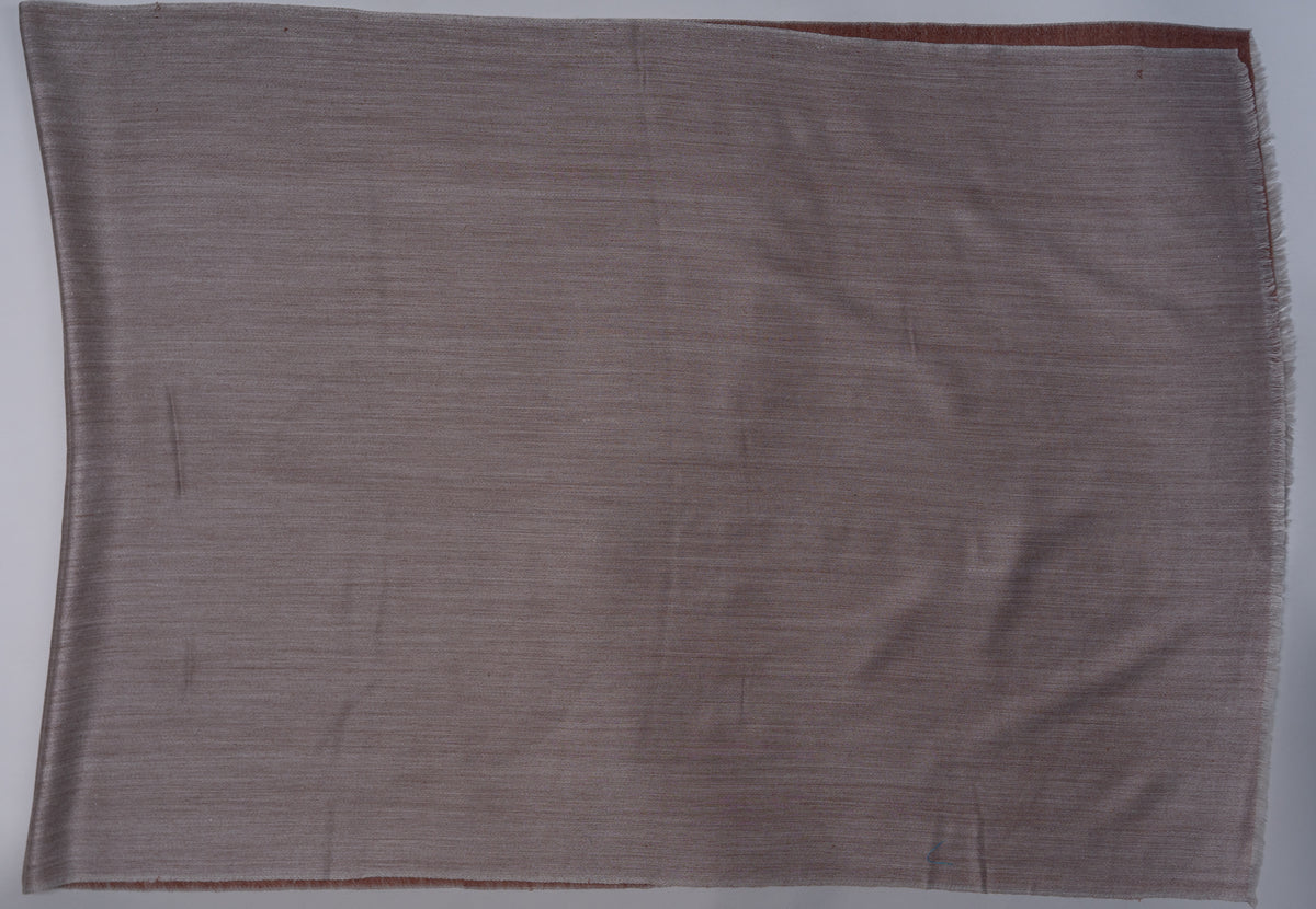 Sand-grey side of the reversible stole laid flat, with a narrow cinnamon edge visible beneath