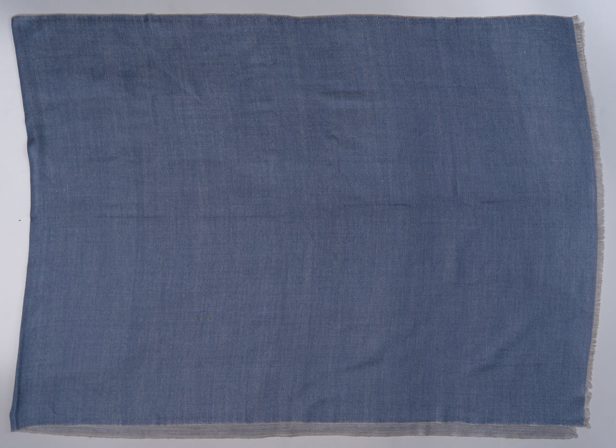 Blue face of the rectangular stole laid flat, showing a plain field, subtle texture and short pale fringe.