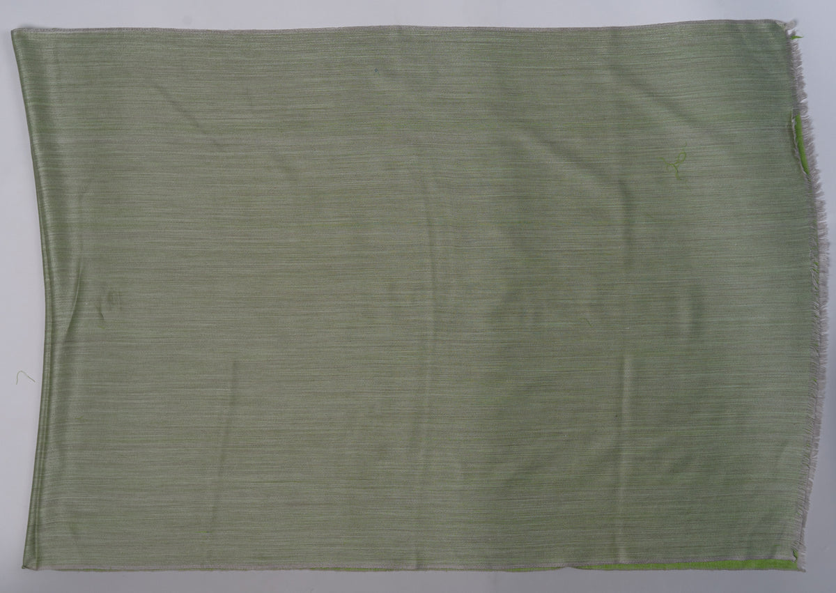 Mist-grey side of a reversible Merino wool stole laid flat, showing its fine weave and a slim green edge