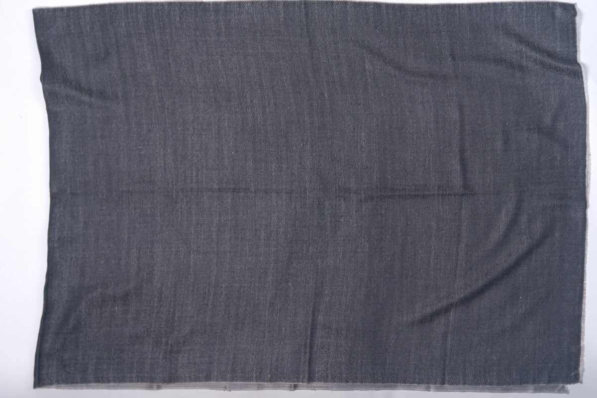 Charcoal side of a reversible Merino wool stole spread flat, showing its rectangular shape and fine woven texture