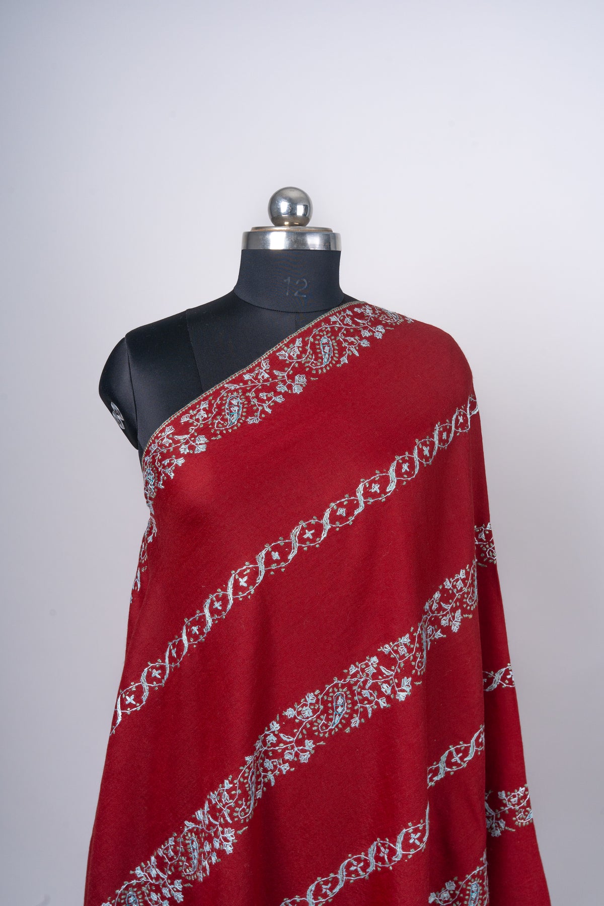 Crimson Merino wool shawl on a mannequin, showing alternating broad floral and narrow scrolling Sozni bands