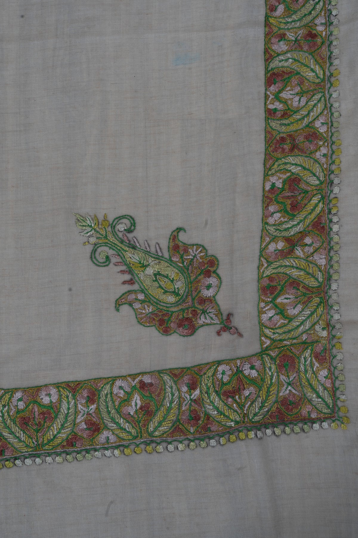 Pale beige rumal corner with a separate green and rose Sozni floral motif beside a broad leafy border