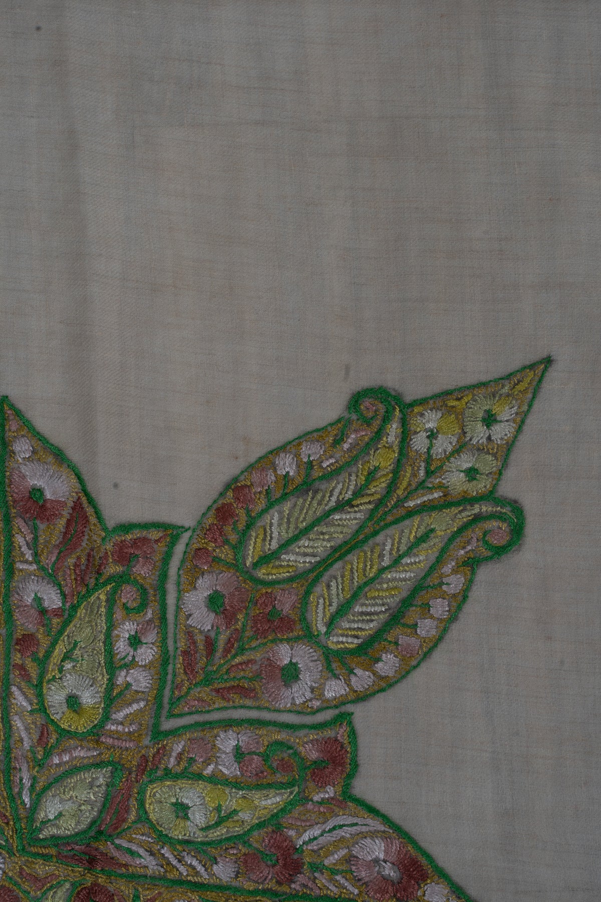 Large green-outlined leaf-shaped corner motif filled with rose flowers and pale gold leaves, joined to the rumal border