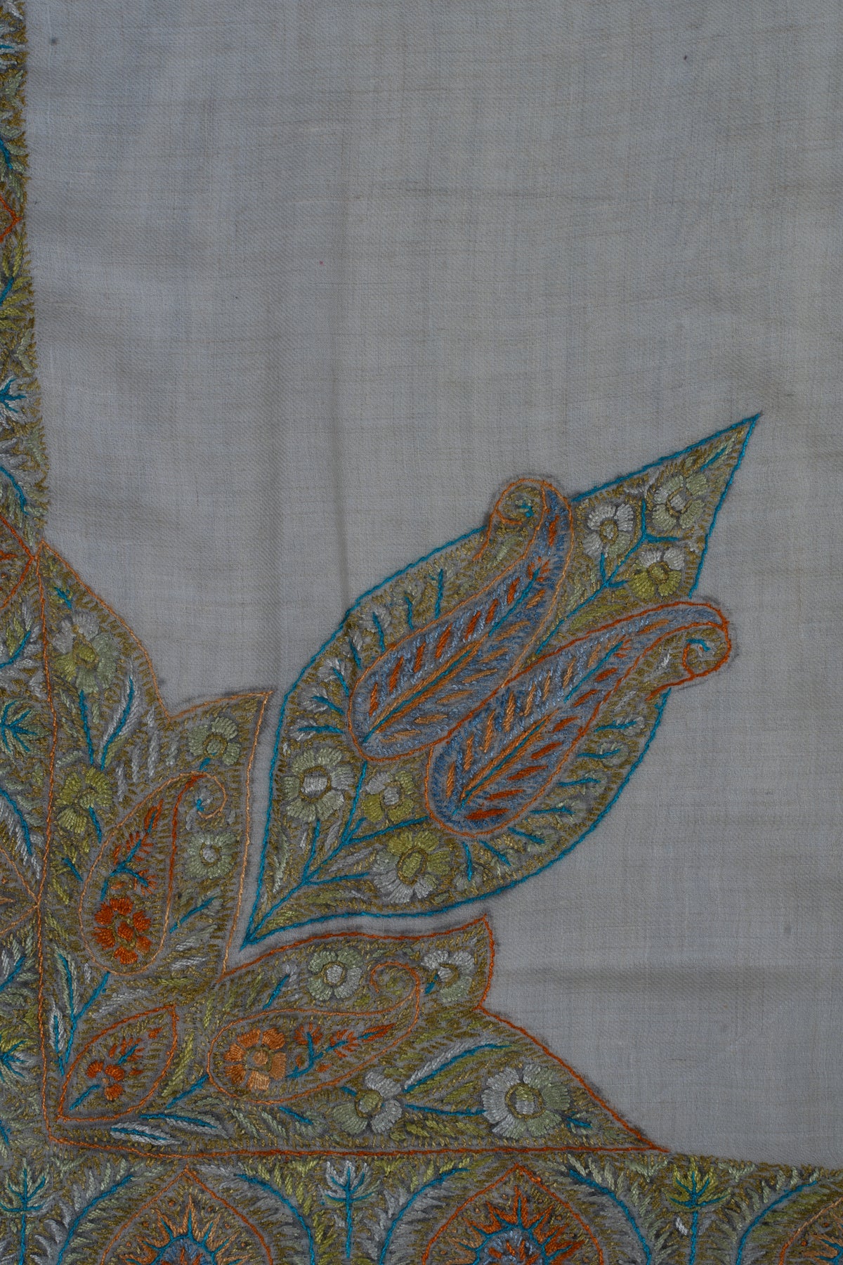 Close-up of a large Sozni leaf motif with amber veins, blue outlines and pale flowers on a cashmere rumal.