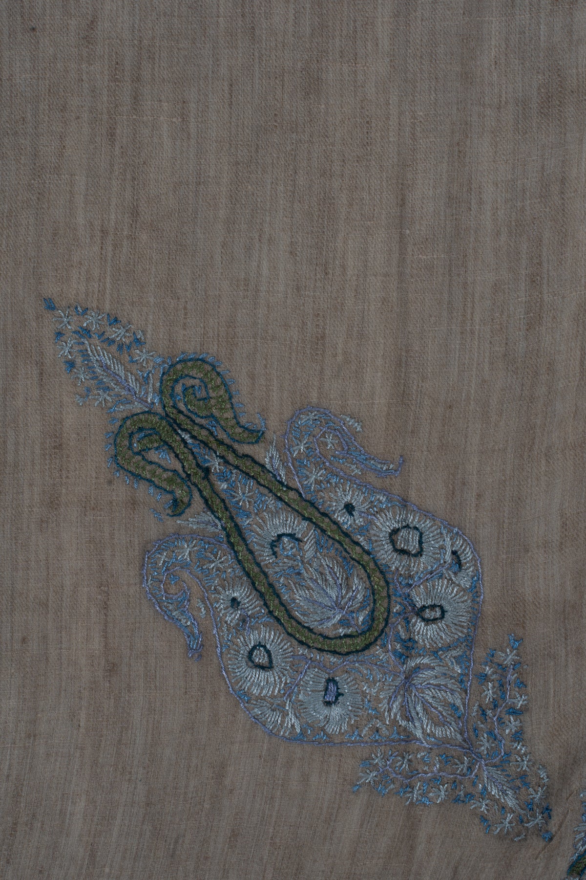 Close-up of the rumal's smaller curled motif with sage outlines and pale blue floral details